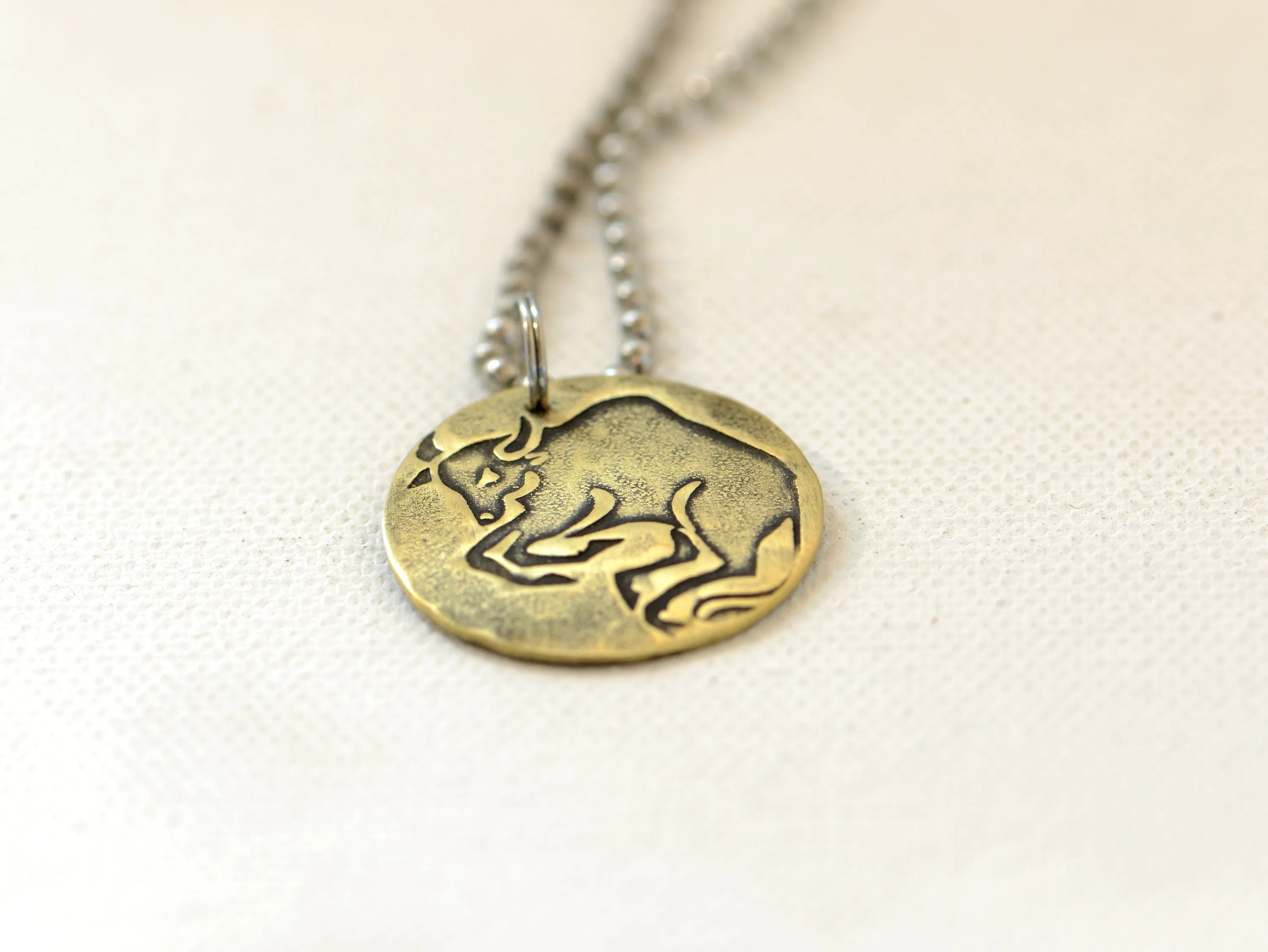 Taurus Zodiac on a brass disc necklace